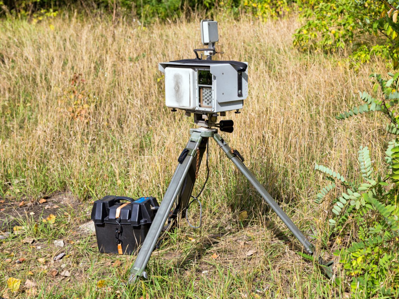 Een camera op statief in een veld, onaangetast door "Verkeersboetes 2019".