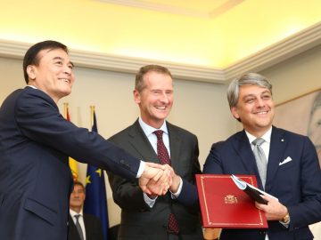 Drie mannen in pak schudden elkaar de hand in China.