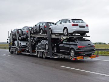 Een dieplader met meerdere auto's erop voor exportgelegenheden.