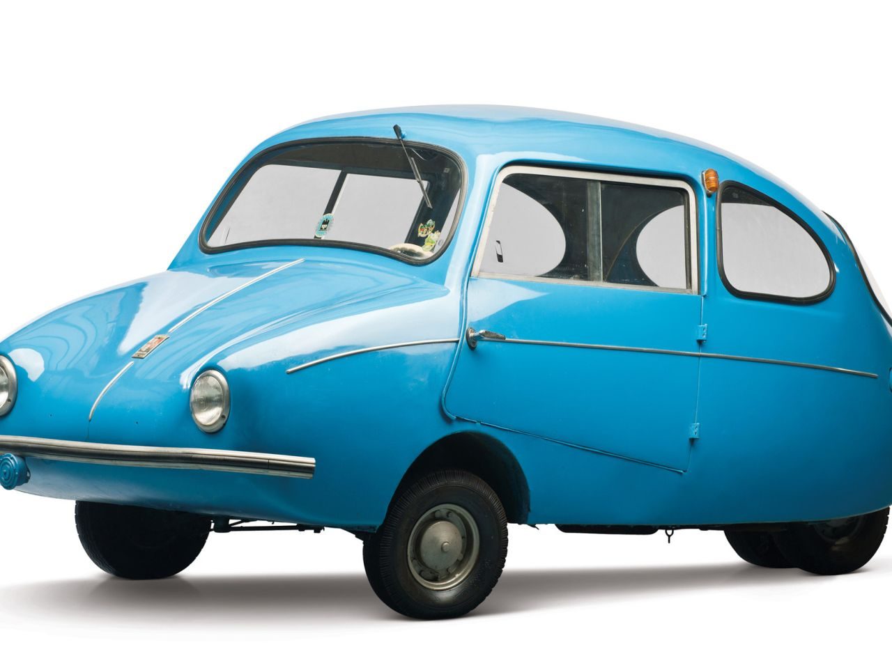 Een kleine blauwe auto op een witte Fulda-achtergrond.