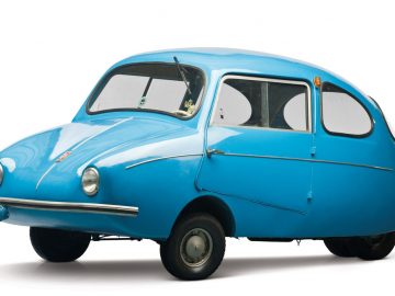 Een kleine blauwe auto op een witte Fulda-achtergrond.