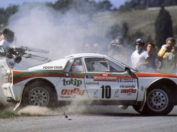 Een rallyauto waar rook uit stroomt.