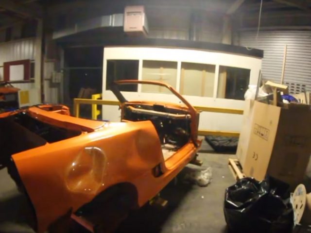 Een oranje Rover zit in een pakhuis.