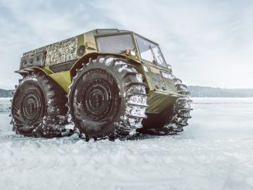 Een groot militair Sherp-voertuig op een besneeuwd veld.