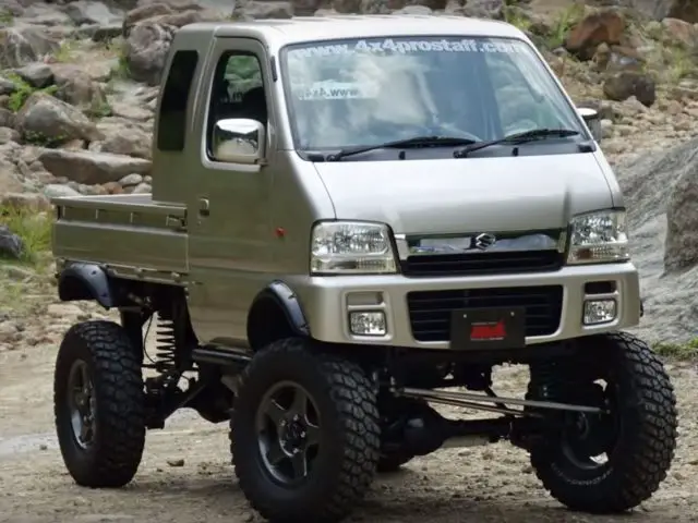 Een zilveren vrachtwagen staat geparkeerd op een onverharde weg in Japan.