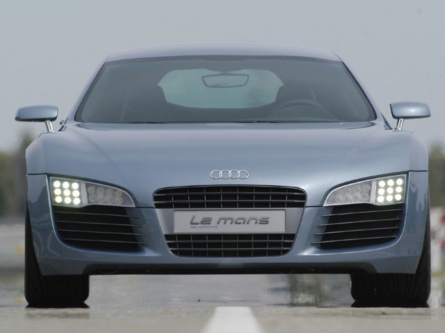 De Audi R8 rijdt met schijnende LED-koplampen over de weg.