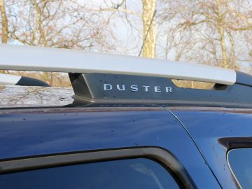 Een Dacia Duster SUV met het woord "Duster" op het imperiaal.