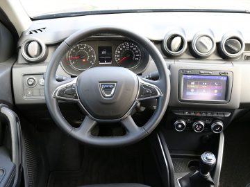 Het dashboard en het stuur van een Dacia Duster.
