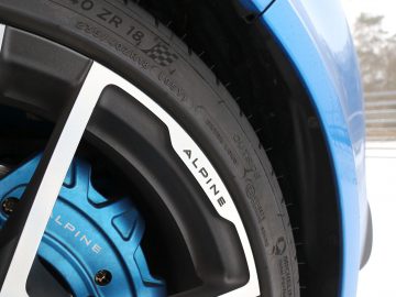 Een close-up van een blauw Alpine A110 wiel en band.