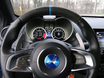 Het dashboard van een blauwe Alpine A110-sportwagen.