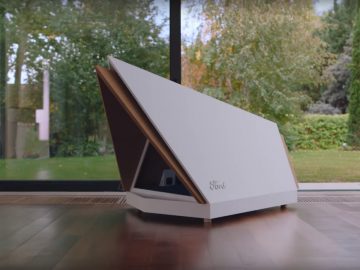 Een wit hondenhok zittend op een houten vloer voor een raam.