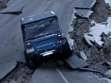 Een jeep rijdt over een bergweg.