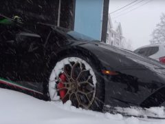 Een zwarte lamborghini ligt onder de sneeuw in een garage.