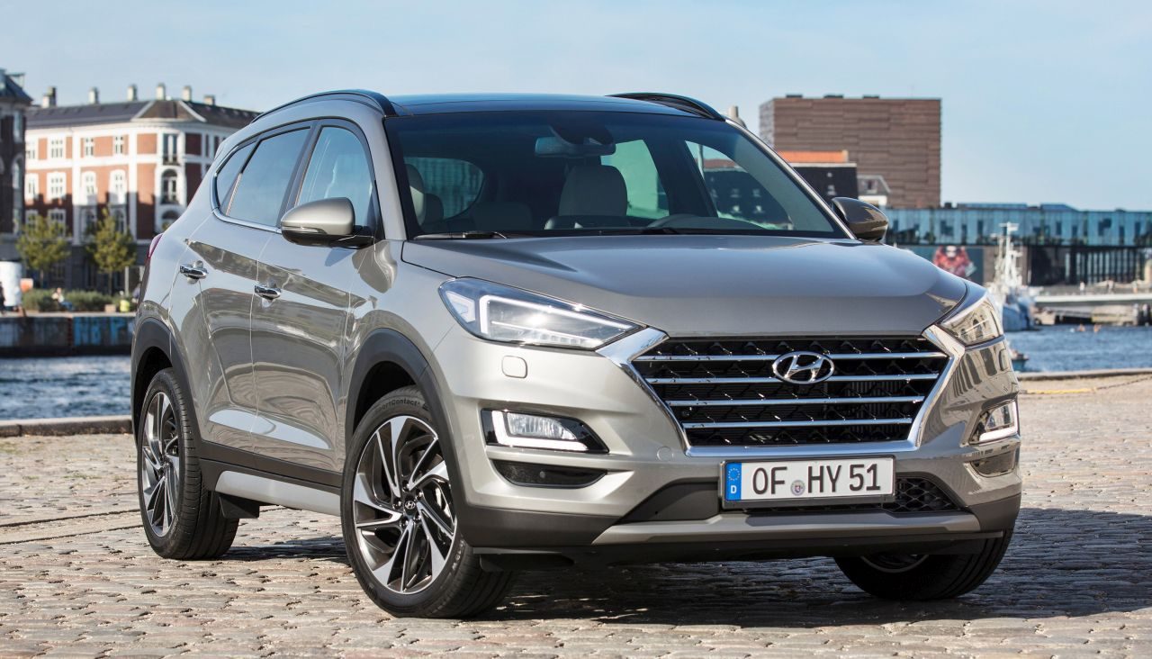 De Hyundai Tucson uit 2019 staat geparkeerd op een geplaveide straat.