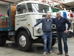 Twee mannen staan naast de oudste DAF-truck in een garage.