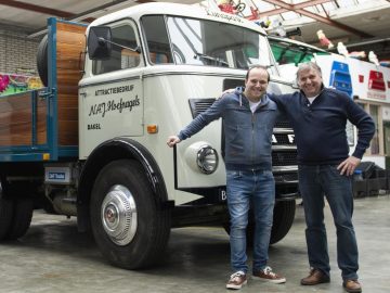 Twee mannen staan naast de oudste DAF-truck in een garage.