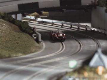 Een slotracentrein rijdt over een spoor.