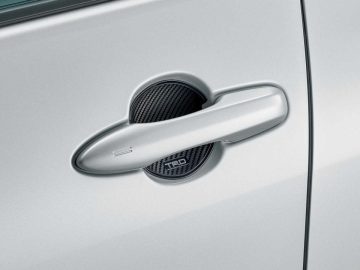 Een close-up van een TRD-deurkruk op een witte auto.