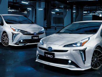 Twee witte Toyota Prius met TRD-upgrades geparkeerd in een garage.