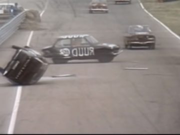 Op een racecircuit staat een DAF-auto bovenop een andere auto.