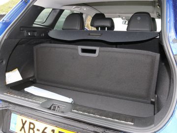 De kofferbak van een blauwe Renault Kadjar is open.