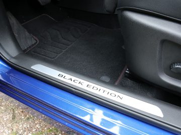 Een blauwe Renault Kadjar met een zwarte vloermat.