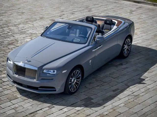 De op maat gemaakte Rolls Royce cabriolet staat geparkeerd op een geplaveide weg.