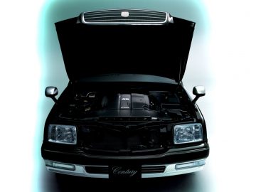 De motorkap van een zwarte auto uit de vorige eeuw met open kap.
