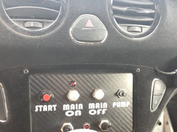 Het dashboard van de Adam R2 met een radio en knoppen.