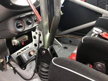 Het interieur van een Adam R2-raceauto met een stuur en bedieningselementen.