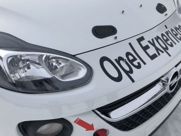 Een witte auto met de woorden "Opel Adam R2 Experience" erop.