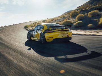 De Porsche Cayman GTS rijdt over een weg.
