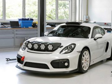 Een witte Porsche Cayman geparkeerd in een garage.