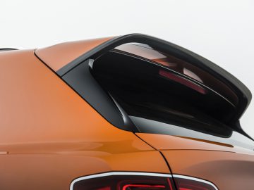 Het achteraanzicht van een oranje Bentley Bentayga Speed.