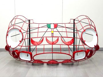 Een rood-witte Halmo kattenkooi, zittend op een houten vloer.