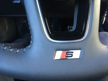 Het stuur van een Audi A1-auto met een logo erop.