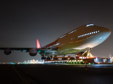 Een groot Boeing 747-vliegtuig op een landingsbaan 's nachts.