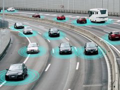 Een groep zelfrijdende auto's op een snelweg met blauwe lichten.