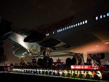 Een grote Boeing 747 die 's nachts op de grond zit.