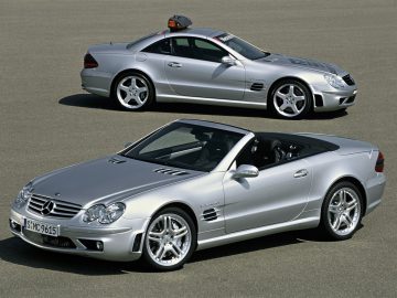 Twee zilveren Mercedes-Benz SL-cabrio's geparkeerd naast elkaar.