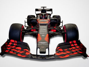 Een rode en zwarte Verstappen-raceauto op een witte achtergrond.