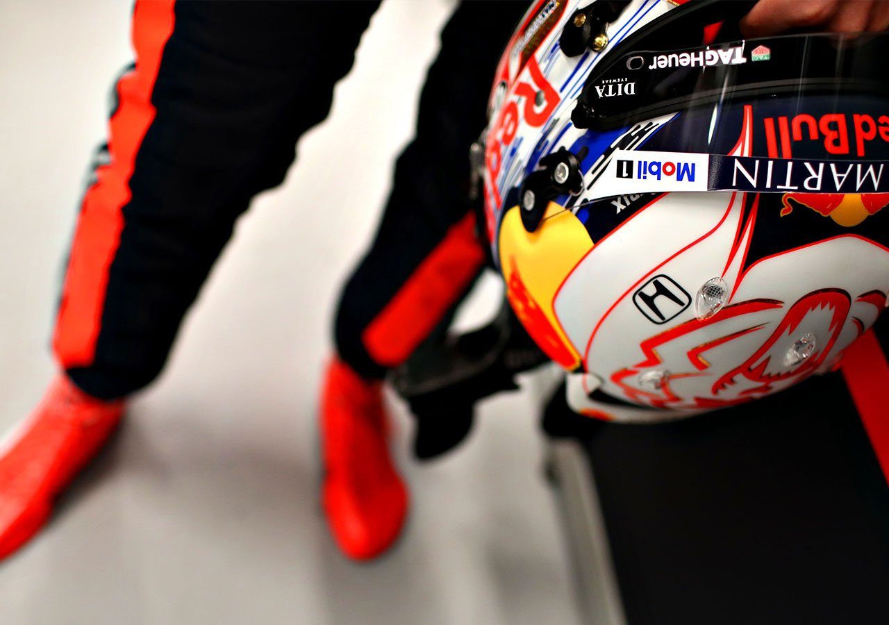 Een persoon met een Red Bull-racehelm gesigneerd door Verstappen.