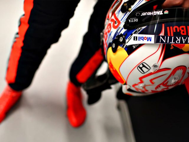 Een persoon met een Red Bull-racehelm gesigneerd door Verstappen.