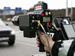 Een persoon die een camera vasthoudt op een weg met flitsers.