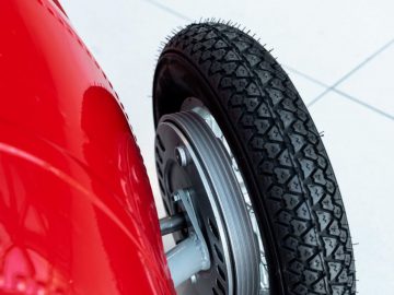 Een close-up van een band van een rode auto bij 250F weer.