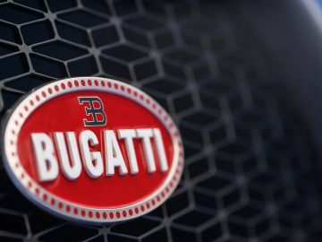 Een close-up van het Bugatti-logo op een blauwe auto.