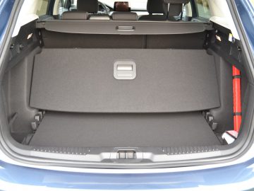 De kofferbak van een blauwe auto, met de nadruk op voldoende opbergruimte.