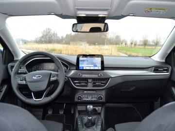 Het interieur van een auto, met de nadruk op het dashboard en het stuur.