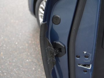Een close-up focus op de deurklink van een blauwe auto.