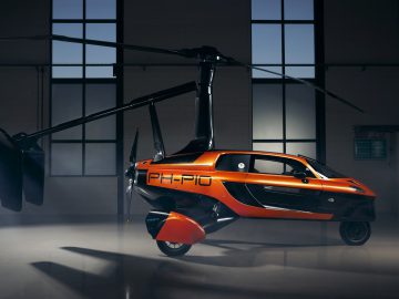 Een Pal-V-helikopter staat geparkeerd in een donkere kamer.